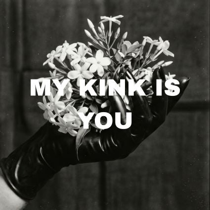 Hand wearing a black latex glove is holding a bouquet of jasmine flowers with MY KINK IS YOU written over them