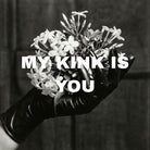 Hand wearing a black latex glove is holding a bouquet of jasmine flowers with MY KINK IS YOU written over them