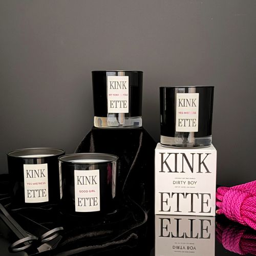 Collection of 'KINKETTE' candles and packaging on a dark surface with a pink rope.