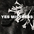 Black heart shaped lock and a bunch of tobacco flowers are shown against a black leather background